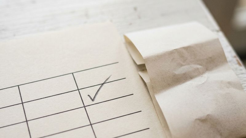 A blank form grid beside a transaction printout with one row ticked in pencil.