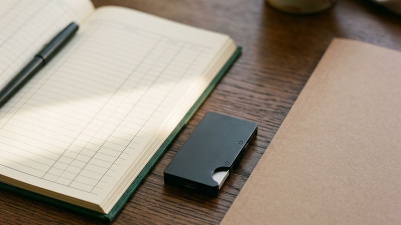 Transaction records beside a hardware wallet and a tax document folder.